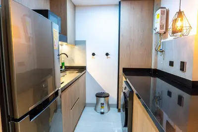 a kitchen with a sink and a large refrigerator at Stylish Laureles Apartment, New Apartment in Medellín