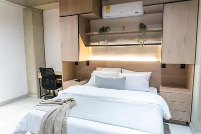 a bedroom with a large white bed and a desk at Stylish Laureles Apartment, New Apartment in Medellín