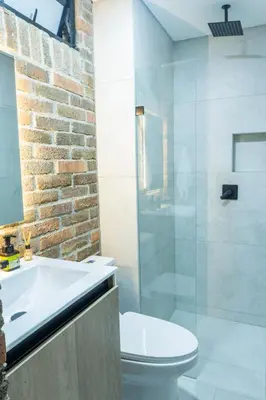 a bathroom with a toilet and a glass shower at Stylish Laureles Apartment, New Apartment in Medellín