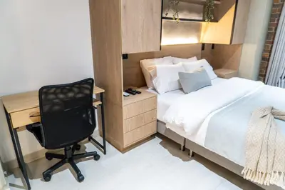a bedroom with a bed and a desk and a chair at Stylish Laureles Apartment, New Apartment in Medellín