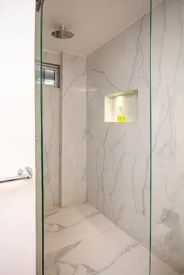 a bathroom with a shower with a glass door at CozyHomesco in Medellín
