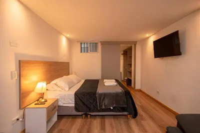 a bedroom with a bed and a flat screen tv at CozyHomesco in Medellín