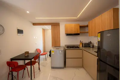 a small kitchen with a table and a refrigerator at CozyHomesco in Medellín
