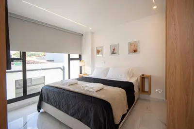 a bedroom with a bed and a large window at Cozyhomesco 1 in Medellín