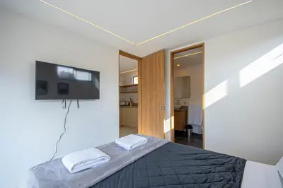 a bedroom with a bed and a flat screen tv at Cozyhomesco 1 in Medellín