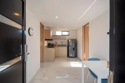a small kitchen with a refrigerator and a table at Cozyhomesco 1 in Medellín