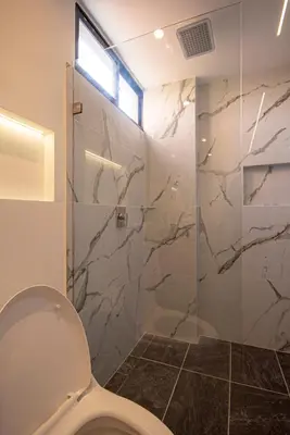 a bathroom with a toilet and a glass shower at Cozyhomesco 1 in Medellín