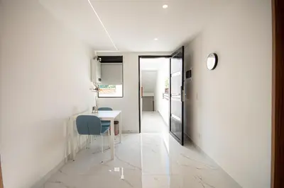 a hallway with a table and a clock on a wall at Cozyhomesco 1 in Medellín