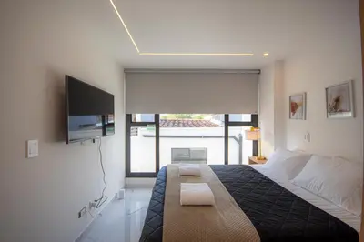 a bedroom with a bed and a flat screen tv at Cozyhomesco 1 in Medellín