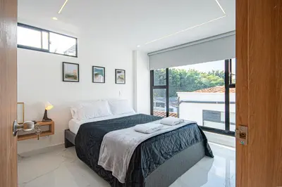 a bedroom with a bed and a large window at Cozyhomesco 1 in Medellín