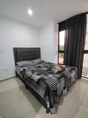 a bedroom with a bed and a large window at Apartamento loft amoblado Medellin in Medellín