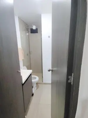 a bathroom with a toilet and a sink and a door at Apartamento loft amoblado Medellin in Medellín