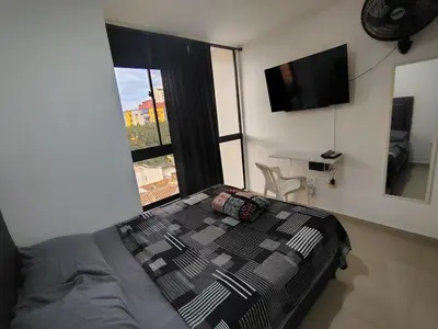a bedroom with a bed and a large window at Apartamento loft amoblado Medellin in Medellín