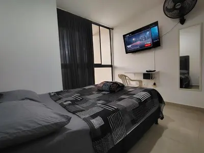 a bedroom with a bed with a television on the wall at Apartamento loft amoblado Medellin in Medellín