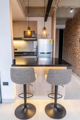 a kitchen with two bar stools in front of a counter at New Apartment in Laureles, Modern & Total Comfort in Medellín