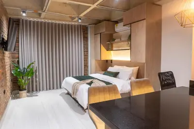 a bedroom with a bed and a kitchen with a table at New Apartment in Laureles, Modern & Total Comfort in Medellín