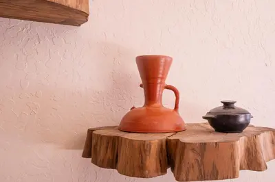 an orange vase and a vase on a wooden table at Casa Museo Living by HOUSY in Medellín