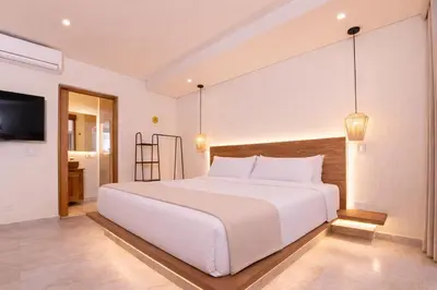 a bedroom with a large white bed and a television at Casa Museo Living by HOUSY in Medellín