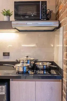 three pots and pans on a stove in a kitchen at Brand New Premium Apartment with Large Balcony in Medellín