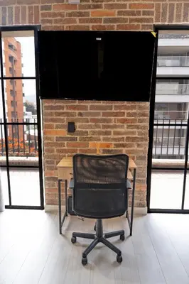 a black chair sitting in front of a brick wall at Brand New Premium Apartment with Large Balcony in Medellín