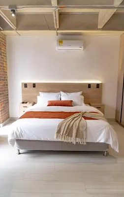 a bedroom with a large bed and a brick wall at Brand New Premium Apartment with Large Balcony in Medellín