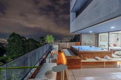 a balcony with a hot tub and a bed at Medellin Sky Penthouse in Envigado