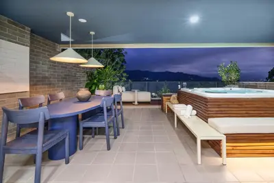 a patio with a table and chairs and a hot tub at Medellin Sky Penthouse in Envigado