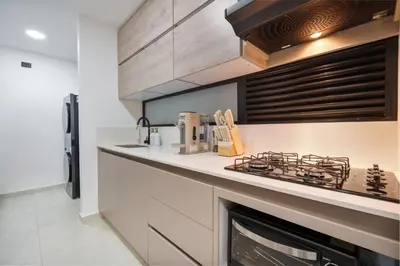 a kitchen with a stove top oven next to a fireplace at Medellin Sky Penthouse in Envigado