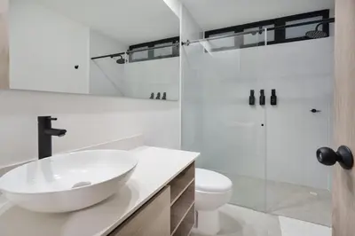 a white bathroom with a sink and a shower at Medellin Sky Penthouse in Envigado