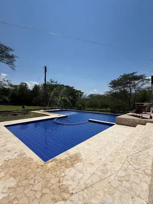 a swimming pool with blue water in a yard at Finca Villa Sofía in Santa Fe de Antioquia