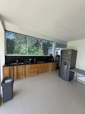 a kitchen with wooden cabinets and a large window at Finca Villa Sofía in Santa Fe de Antioquia
