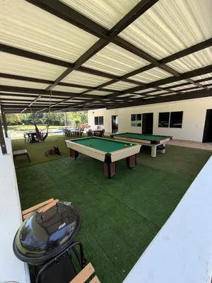 a covered patio with two ping pong tables in it at Finca Villa Sofía in Santa Fe de Antioquia