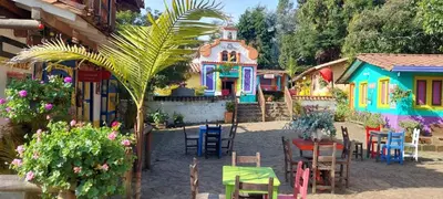 a group of houses with tables and chairs and a building at Cabañas Miraluna in Santa Elena