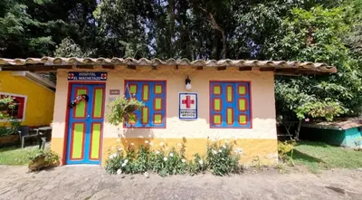 a small house with colorful doors in a yard at Cabañas Miraluna in Santa Elena