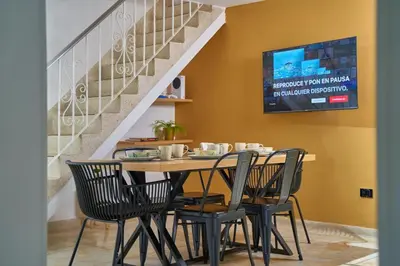 a dining room with a table with chairs and a staircase at Casa en Laureles Estadio amplia y cómoda in Medellín