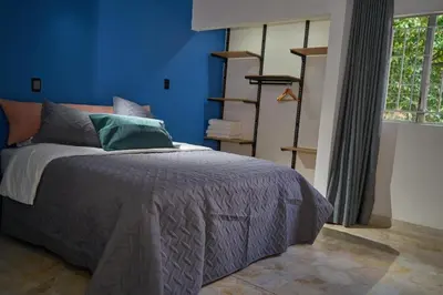a bedroom with a bed with a blue wall at Casa en Laureles Estadio amplia y cómoda in Medellín