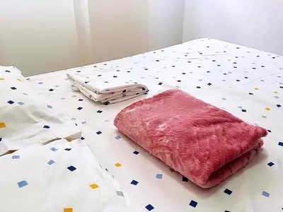 a bed with a pink pillow on top of it at Cómoda Habitación condominio, wifi, tv, piscina in Medellín