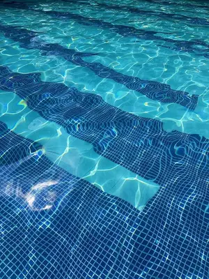 a swimming pool with a pattern of blue water at Cómoda Habitación condominio, wifi, tv, piscina in Medellín