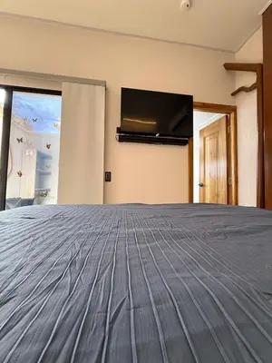 a bedroom with a bed and a flat screen tv at Villa Patio Colonial Santa Fe de Antioquia in Santa Fe de Antioquia