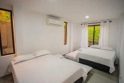 a room with two beds and a window at Casa Finca Moderna en Sopetran, Antioquia in Sopetran