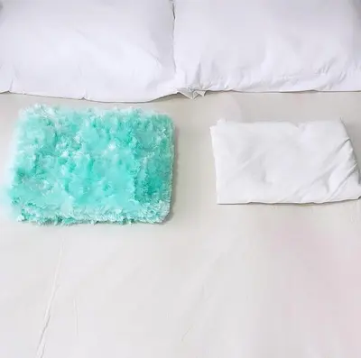 a bed with two pillows and a green and white pillow at Cómoda Habitación condominio, wifi, piscina in Medellín