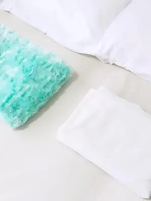 a pile of white and blue towels on a bed at Cómoda Habitación condominio, wifi, piscina in Medellín