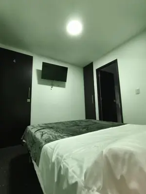 a bedroom with a bed and a flat screen tv at Hotel LAS MARIANA'S in Medellín