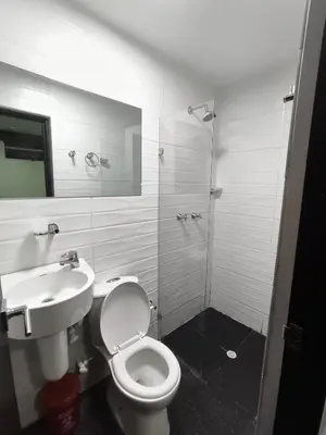 a bathroom with a toilet and a sink and a shower at Hotel LAS MARIANA'S in Medellín