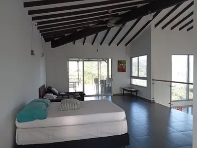 a bedroom with a large bed in a room at Finca La Catana, Naturaleza y Tranquilidad in Cocorná