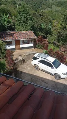 a white car parked in front of a house at Finca La Catana, Naturaleza y Tranquilidad in Cocorná