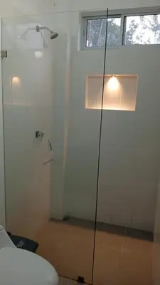 a bathroom with a shower and a toilet and a window at Finca La Catana, Naturaleza y Tranquilidad in Cocorná
