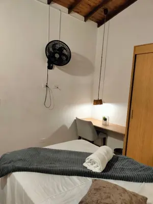 a bedroom with a bed and a desk with a fan at Diseño natural y espacioso, vista panorámica de Medellín 501 in Medellín
