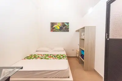 a small room with two beds and a cabinet at Hotel Casa Encanto in Doradal