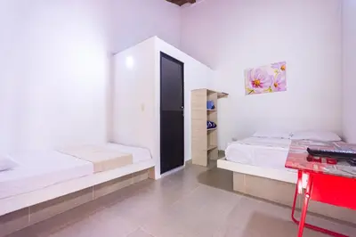 a bedroom with two beds and a red desk at Hotel Casa Encanto in Doradal